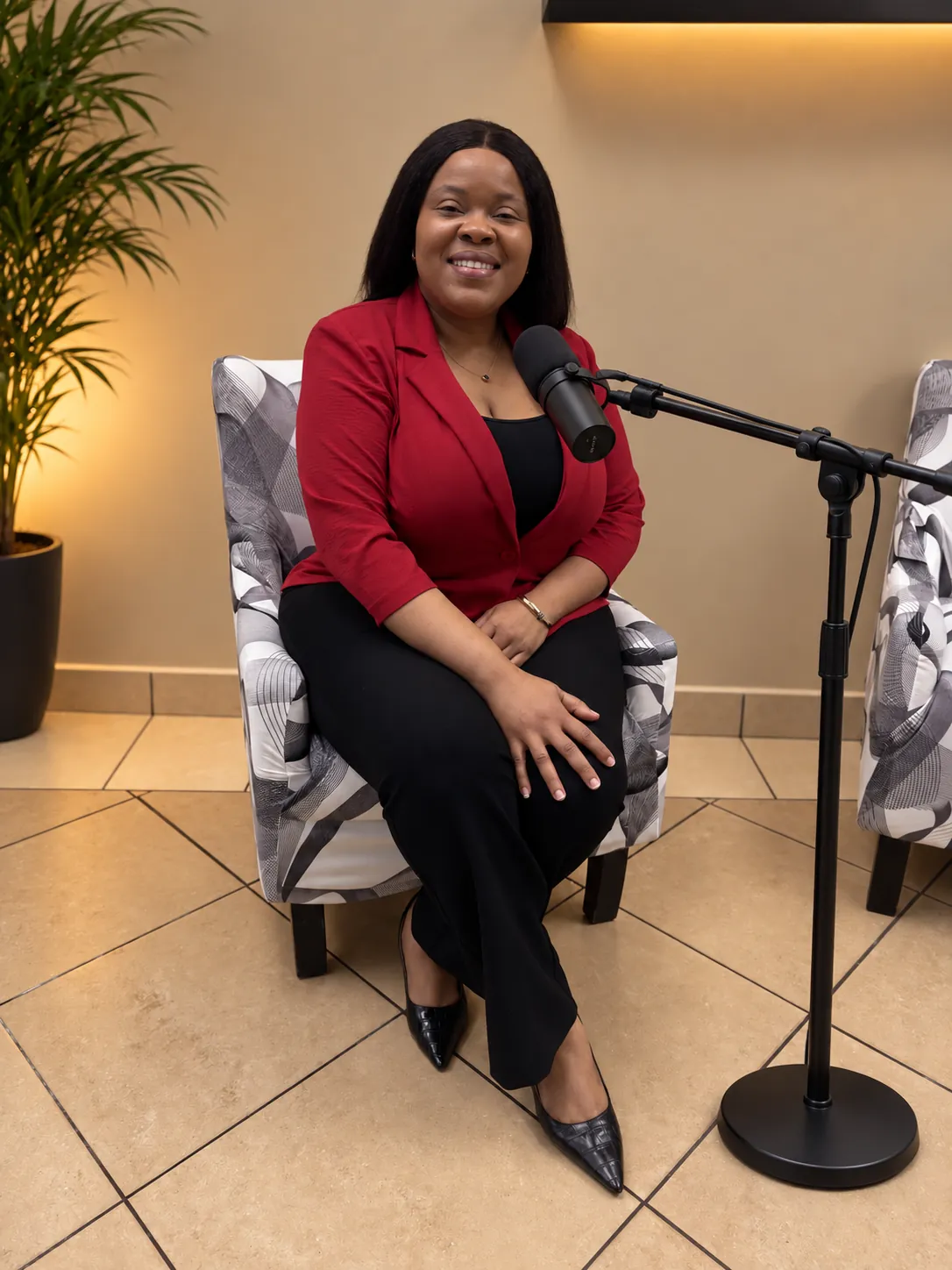 Natacha Alcindor seated, smiling, in a red blazer